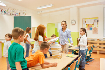 Obraz premium Students stacking books on bench in class