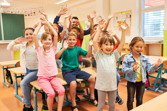 Group of elementary students waving in class