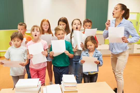 School children singing choir with female teacher