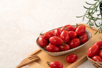 Fresh cherry tomatoes over white table background.