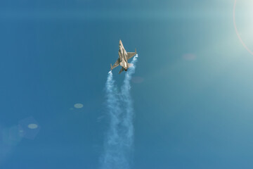 Crete, Greece - November, 11, 2019: F-16 fighting military fighter jet airplane flying with smoke against blue sky background.