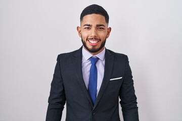 Young hispanic man wearing business suit and tie with a happy and cool smile on face. lucky person.