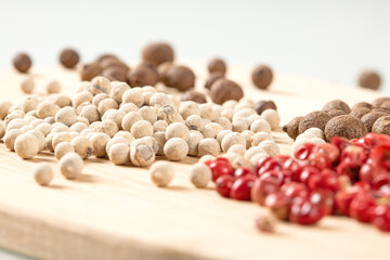 Macro shot of a mixture of black, white, and red peppercorns in close-up view