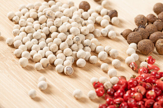 Close-up view of a colorful blend of black, white, and red peppercorns in macro photography
