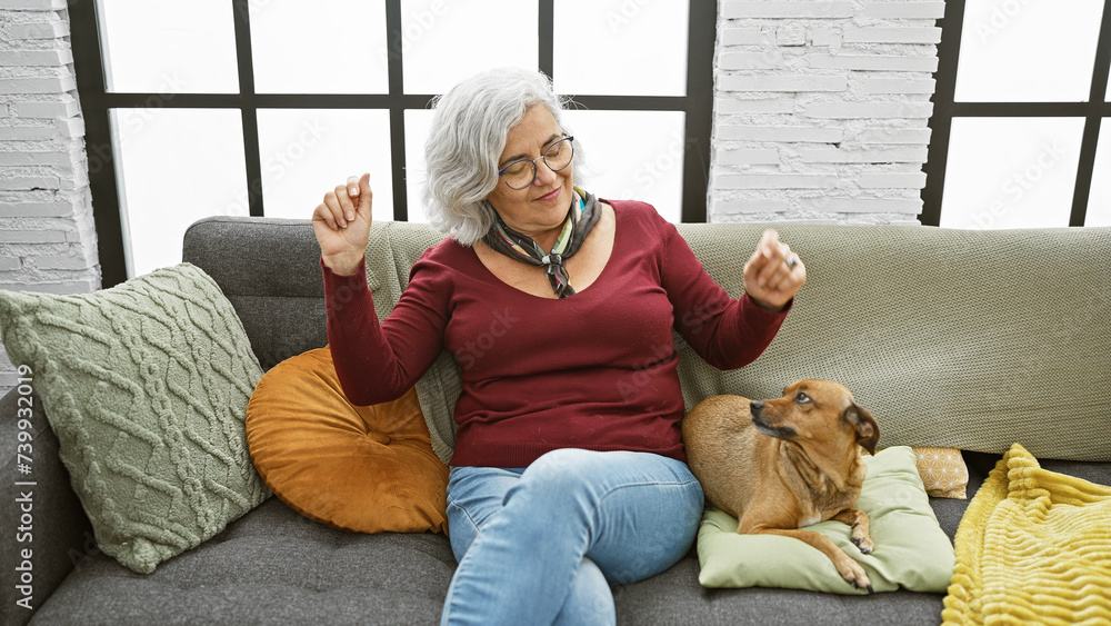 Sticker a grey-haired woman enjoys dancing on a cozy sofa with her dog in a modern living room setting.