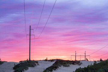 Silhouette of large overhead power lines during sunrise in Estonia, Northern Europe	