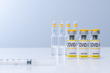 Vaccine in glass vial with syringe on a table. Vaccination and Medical concept.