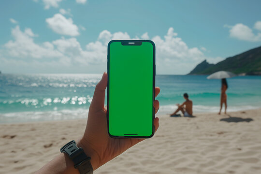 Mockup of an iPhone with a green screen, hand holding an iPhone, on the beach