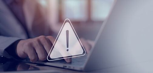 Businessman uses laptop with warning triangle sign for notification, found error and maintenance...