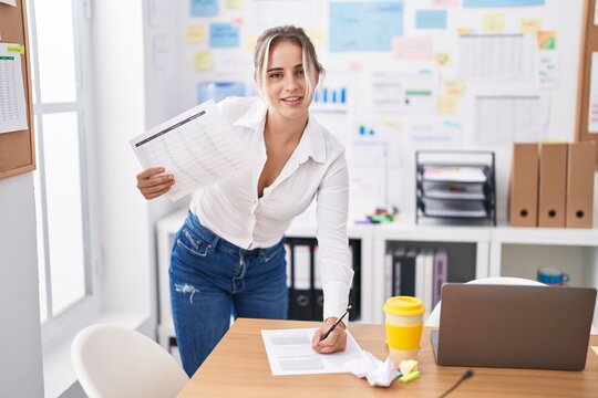 Young blonde woman business worker writing on document standing at office