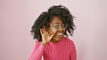 Smiling african american woman with glasses, indoors against a pink background, portraying...