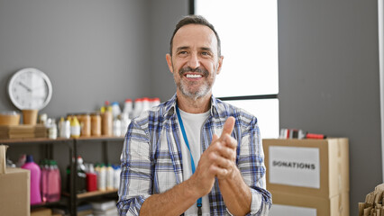 Charismatic, grey-haired, middle-age man enthusiastically clapping in joyful applause as a...