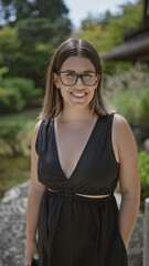 Joyful and confident, a beautiful hispanic woman in glasses stands by the serene ginkaku-ji temple,...