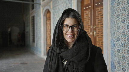 Smiling woman with glasses in topkapi palace, istanbul, showcasing multicultural tourism and...