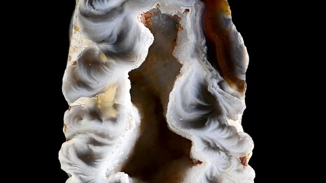 Agate - polished cross-section of geode, rotating slowly against a black background