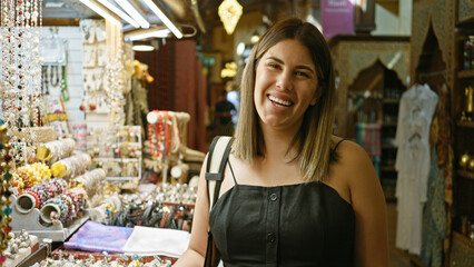 Smiling woman shopping in traditional souk in dubai, with jewelry and artifacts.
