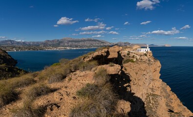 view of the Albir Lighthouse on the rocvky promontory in the Serra Gelada Natural Park between Benidorm and Altea