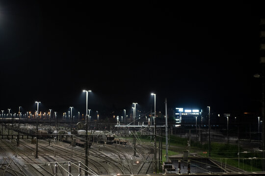 Freight station at night in Zurich, Spreitenbach. Freight trains are illuminated by bright headlights. In the background is a light layer of fog.