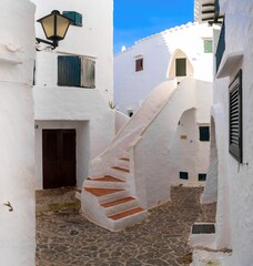 courtyard with whitewashed houses and stairs in the village center of Binibeca Vell