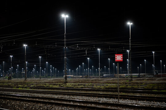 Freight station at night in Zurich, Spreitenbach. Freight trains are illuminated by bright headlights. In the background is a light layer of fog.