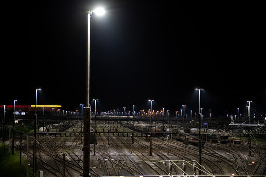 Freight station at night in Zurich, Spreitenbach. Freight trains are illuminated by bright headlights. In the background is a light layer of fog.