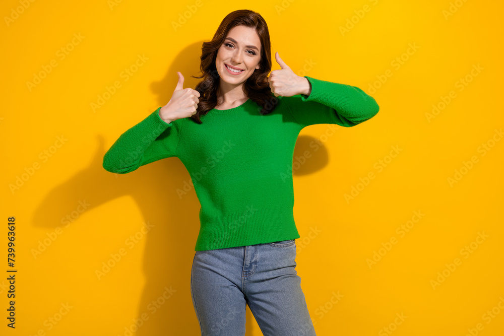 Wall mural Photo of positive satisfied nice girl arms fingers demonstrate thumb up isolated on yellow color background