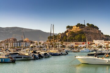 view of the sports marina and harbour and historic hilltop castle in the old town center of Denia