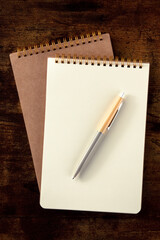 Notebook mockup with a pen, top shot on a rustic wooden desk - 739966645
