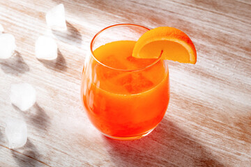 Orange drink on a wooden background, fresh pressed juice with a fruit slice and ice - 739969263