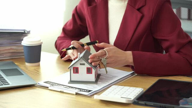 Young Asian female real estate agent using a home buying budget calculator calculates financial risks for clients before signing deals. Advisory ideas and introduction 4k close-up