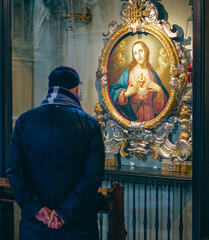 Man from behind admiring a portrait of Jesus
