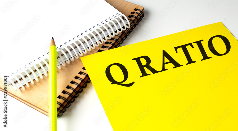 Poster q ratio text written on a yellow paper with notebook