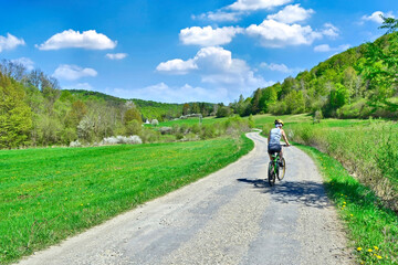 Healthy lifestyle - Woman riding a bicycle on a sunny spring day, Olchowiec, Low Beskids, Poland