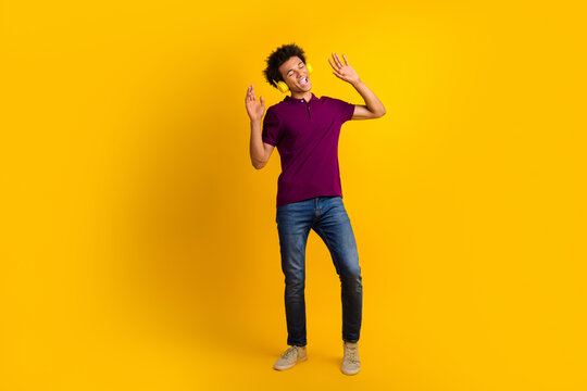 Photo of cheerful glad man closed eyes wear trendy clothes listen music mp3 player enjoy playlist isolated on yellow color background