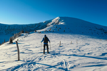 Man in snowshoes on snow covered mountains of Kor Alps, Lavanttal Alps, Carinthia Styria, Austria....