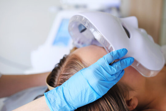 Cosmetic LED Facial Mask Treatment in Progress. Close-up image of a patient receiving a state-of-the-art LED facial mask treatment in a beauty clinic. Horizontal photo