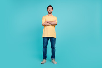 Full body photo of young confident man in yellow t shirt and jeans crossed arms when see his...