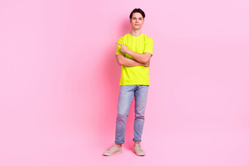 Full length photo of cheerful cool guy wear green t-shirt pointing finger empty space isolated pink color background