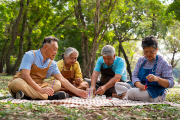 A group of Asian senior people enjoy painting cactus pots and recreational activity or therapy outdoors together  at an elderly healthcare center, Lifestyle concepts about seniority