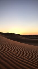 a sand dunes with a sunset in the background