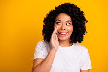 Photo of cunning tricky woman dressed white t-shirt tell secret look empty space palm near mouth...