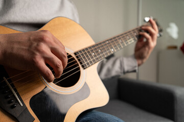 A closeup shot of a man's hand playing the guitar
