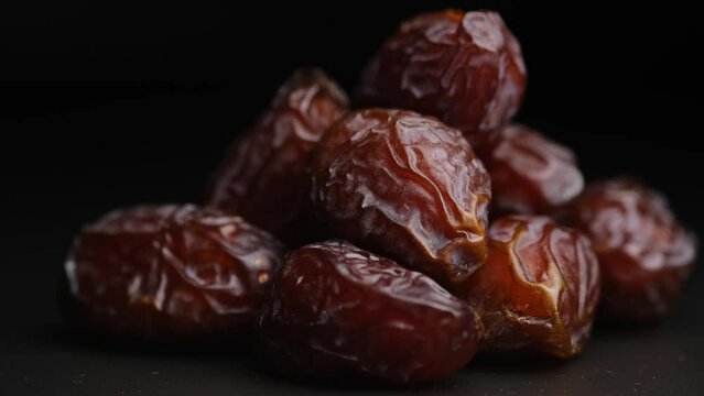 Dried dates, dried fruits on a black background close-up.