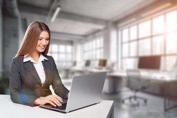 Businesswoman using laptop in modern office.