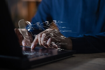 A young businessman wearing a long-sleeved T-shirt is busy working at night. By typing on the...