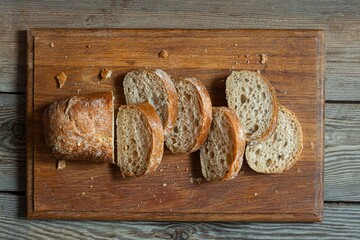 Fresh baked buckwheat (whole grain) bread, on a wooden background. Crispy baguette with a delicate...