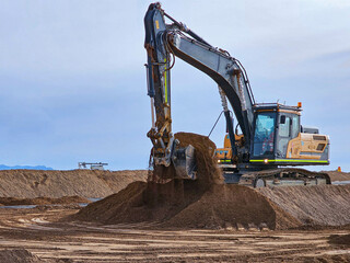 Excavator type construction machinery working on bulk earthworks in a mine.