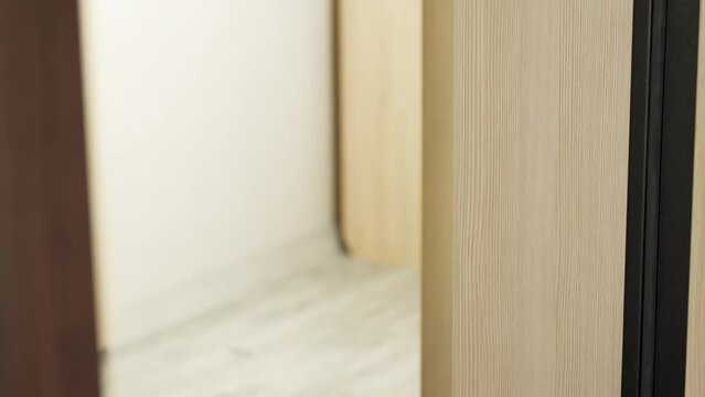 Close-up male hand opening door handle and entering