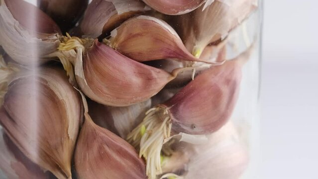 Garlic in a jar on a white background, close-up. Spices.
