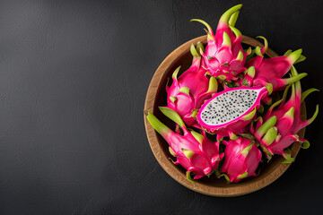 Obraz na płótnie Canvas top view dragon fruit on the wooden bowl and black table